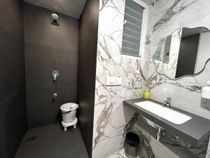 a bathroom with a sink and a marble wall at UHomes Pune airport in Pune +13 photos