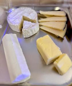 a tray of cheese and other cheeses on a table at Hotel Boutique Casón De Los López in Toledo +163 photos