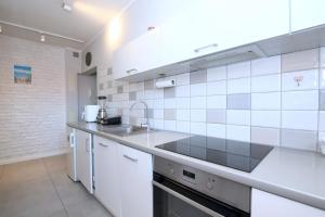 a kitchen with white tile walls and a sink at Perfect Location Apartment with Balcony Oldtown in Gdańsk