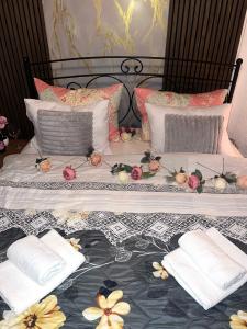 a bed with two pillows and flowers on it at Apartment Jelka 1 lux in Umka
