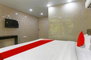 1 dormitorio con 1 cama con almohadas rojas y TV en Hotel O Happy Hours, en Nueva Delhi 21 fotos más