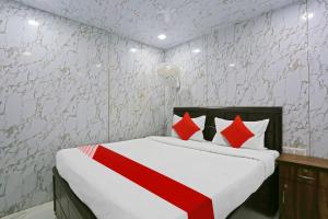 Un dormitorio con una cama con almohadas rojas y blancas. en Hotel O Happy Hours, en Nueva Delhi