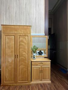 a large wooden cabinet next to a fish tank at Khách sạn Hội An - Kon Tum in Kon Tum