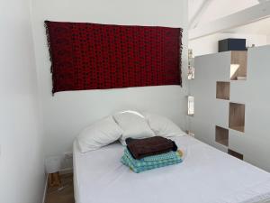a bedroom with a white bed with a red blanket at Studio lumineux avec terrasse et jardin proche de Caen 