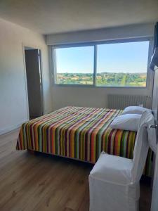 a bedroom with a bed and a large window at les terrasses du Thouet in La Celle-sous-Gouzon