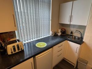 a kitchen with a sink and a counter top at Snug Studio - Minutes Walking from Pleasure Beach - Burlington Road in Blackpool
