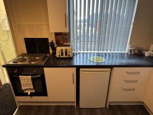 a small kitchen with a stove and a window at Snug Studio - Minutes Walking from Pleasure Beach - Burlington Road in Blackpool