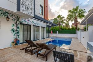 a house with a swimming pool and two chairs at Casa Rosa Luxury Villa w heated Pool in Belek