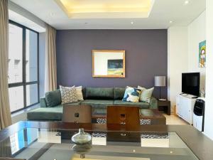 a living room with a green couch and a tv at Mandela Place Apartment in Cape Town