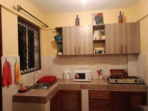 a kitchen with a sink and a microwave at Enkan Naserian in Kilifi