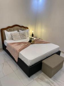 a bedroom with a large bed with a night stand at La Belle Escale in Pikine