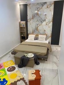 a bedroom with a large bed with a marble wall at La Belle Escale in Pikine +16 photos