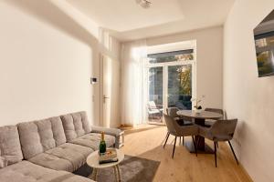 a living room with a couch and a table at Melody Apartments Vienna - Modern & Spacious with Terrace in Vienna