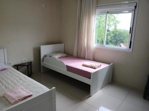 Un dormitorio pequeño con una cama y una ventana. en UNIJUI, en Ijuí