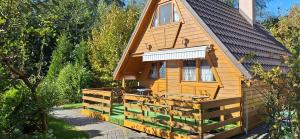 a wooden cabin with a porch and a fence at Uroczysko Domki in Zarzecze