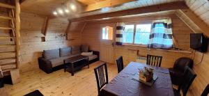 a living room with a table and a couch at Uroczysko Domki in Zarzecze