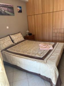 a large bed in a bedroom with wooden cabinets at Cozy apartment in the heart of Tripoli! in Tripolis