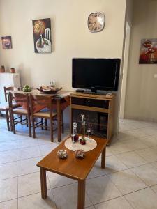 a living room with a flat screen tv and a table at Cozy apartment in the heart of Tripoli! in Tripolis