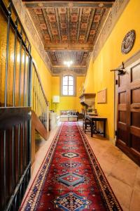 a hallway with a red rug on the floor at Rinascimento Suite Centro Storico Modena in Modena