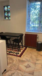 a table in a room with a rug and a window at Stela's Home in Ploieşti
