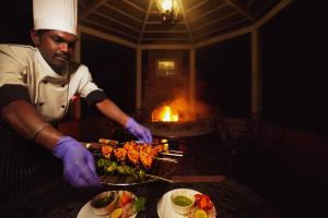 a chef preparing food on a grill on a table at JC Residency in Kodaikānāl +142 photos