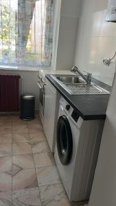a kitchen with a sink and a washing machine at Stela's Home in Ploieşti