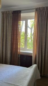 a bedroom with a bed and a window with curtains at Stela's Home in Ploieşti +4 photos