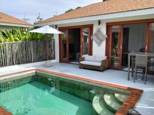 a swimming pool in front of a house at VILLA JADE orchid life residence in Koh Samui