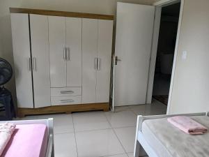 a room with two beds and a closet with white cabinets at UNIJUI in Ijuí