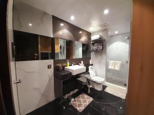 a bathroom with a sink and a toilet and a shower at One Euphoria Prime Suite Hotel Angeles city in Malabañas +15 photos