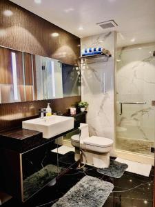 a bathroom with a sink and a toilet and a shower at One Euphoria Prime Suite Hotel Angeles city in Malabañas