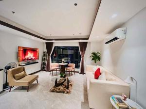 a living room with a couch and a tv at One Euphoria Prime Suite Hotel Angeles city in Malabañas