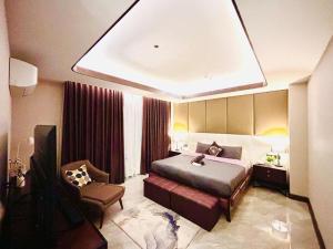 a hotel room with a bed and a chair at One Euphoria Prime Suite Hotel Angeles city in Malabañas
