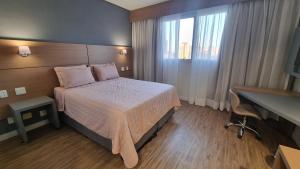 サントスにあるApartamento Santos praia Helbor Stayのベッドと机があるホテルの部屋 +15枚の写真