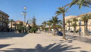 a city street with palm trees and a street light at Pozzallo sole mare in Pozzallo