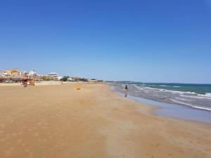 a person walking on the beach near the ocean at Pozzallo sole mare in Pozzallo