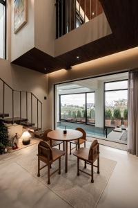 - un salon avec une table, des chaises et une grande fenêtre dans l'établissement Jeju Rapauza Stay, à Yusuam 106 autres photos