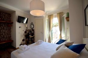 a bedroom with a white bed and a window at Locanda Fra Diavolo in Diano Marina