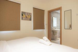 Un dormitorio con una cama y un baño con lavabo. en CasaNova Airport Suites, en Accra