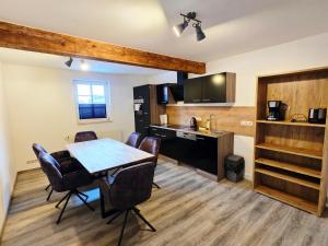 a kitchen and dining room with a table and chairs at Moritz Apartments - Pfarrgasse 11 in Küllstedt
