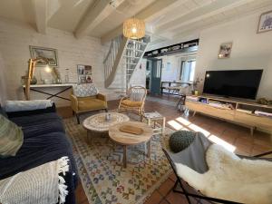 ein Wohnzimmer mit Sofa und Fernseher in der Unterkunft Maison de la Beureliere in Sainte-Marie-de-Ré