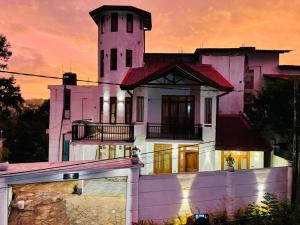 a large white house with a tower on top of it at Aurora White Bungalow Kandy in Kandy