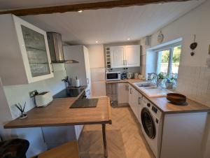 a kitchen with a sink and a stove top oven at Primrose cottage - Upper cwmbran in Pontnewydd