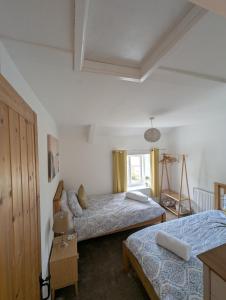 a bedroom with two beds and a window at Primrose cottage - Upper cwmbran in Pontnewydd