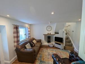 a living room with a couch and a fireplace at Primrose cottage - Upper cwmbran in Pontnewydd