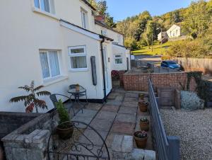 a balcony of a white house with a table and chairs at Primrose cottage - Upper cwmbran in Pontnewydd