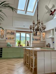 eine Küche mit grünen Schränken und einem Kronleuchter in der Unterkunft Villa Pippi in Tokarnia
