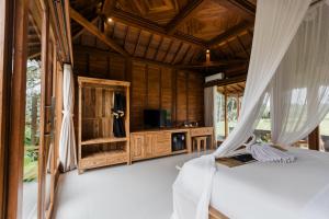 a bedroom in a villa with a bed and curtains at Padi Bali Villa in Payangan
