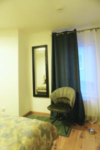 アンクラムにあるModern Comfort Apartment in Anklam - Central Locationのベッドルーム1室(ベッド1台、椅子、鏡付)