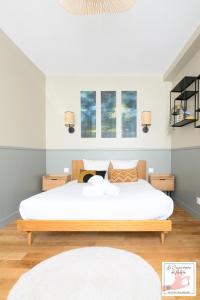 a bedroom with a bed and two windows at Joli gîte centre historique de Milly 2-4 personnes in Milly-la-Forêt